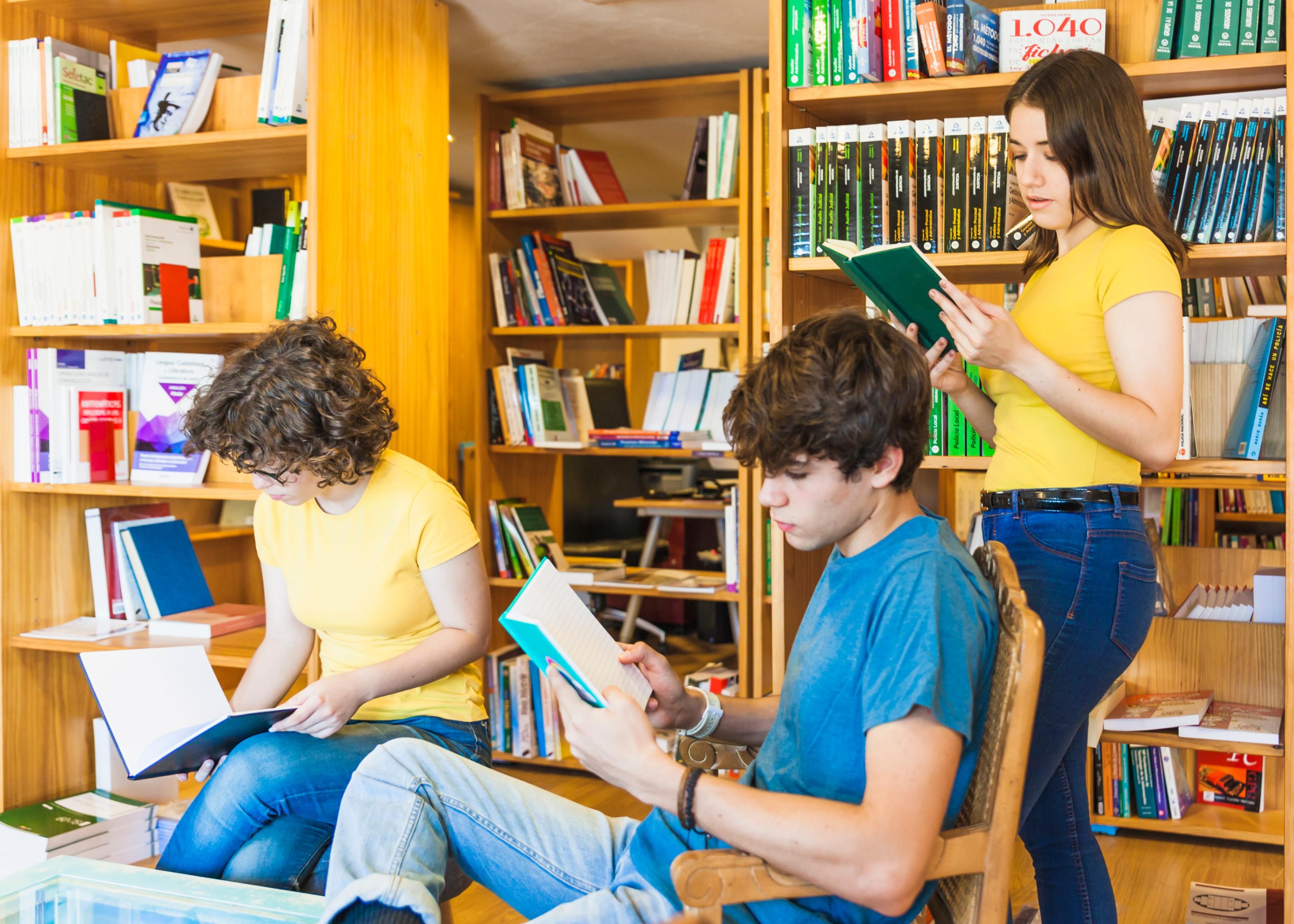Подросток читает книгу. Подростки в библиотеке. Молодежь в библиотеке. Чтение в библиотеке. Молодежь и чтение.
