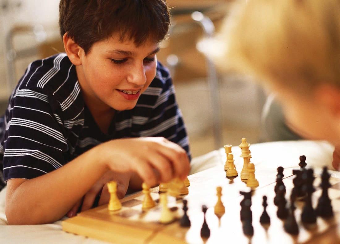 The boy playing chess. Шахматы для детей. Мальчик с шахматами. Мальчик играющий в шахматы. Дети играют в шахматы.