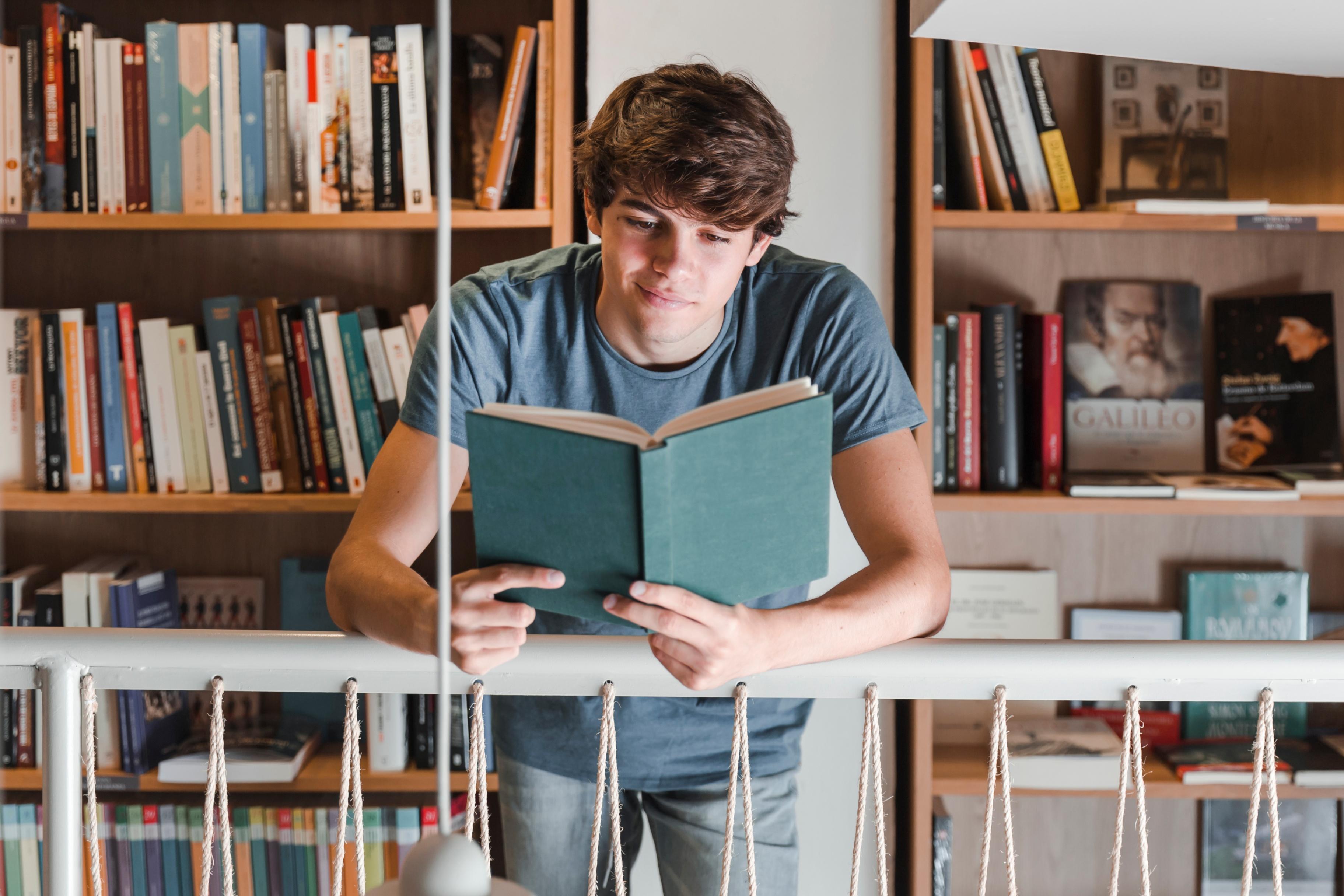 Читать книгу фото. Парень в библиотеке. Подростки в библиотеке. Парень с книгой в библиотеке. Подросток читает.