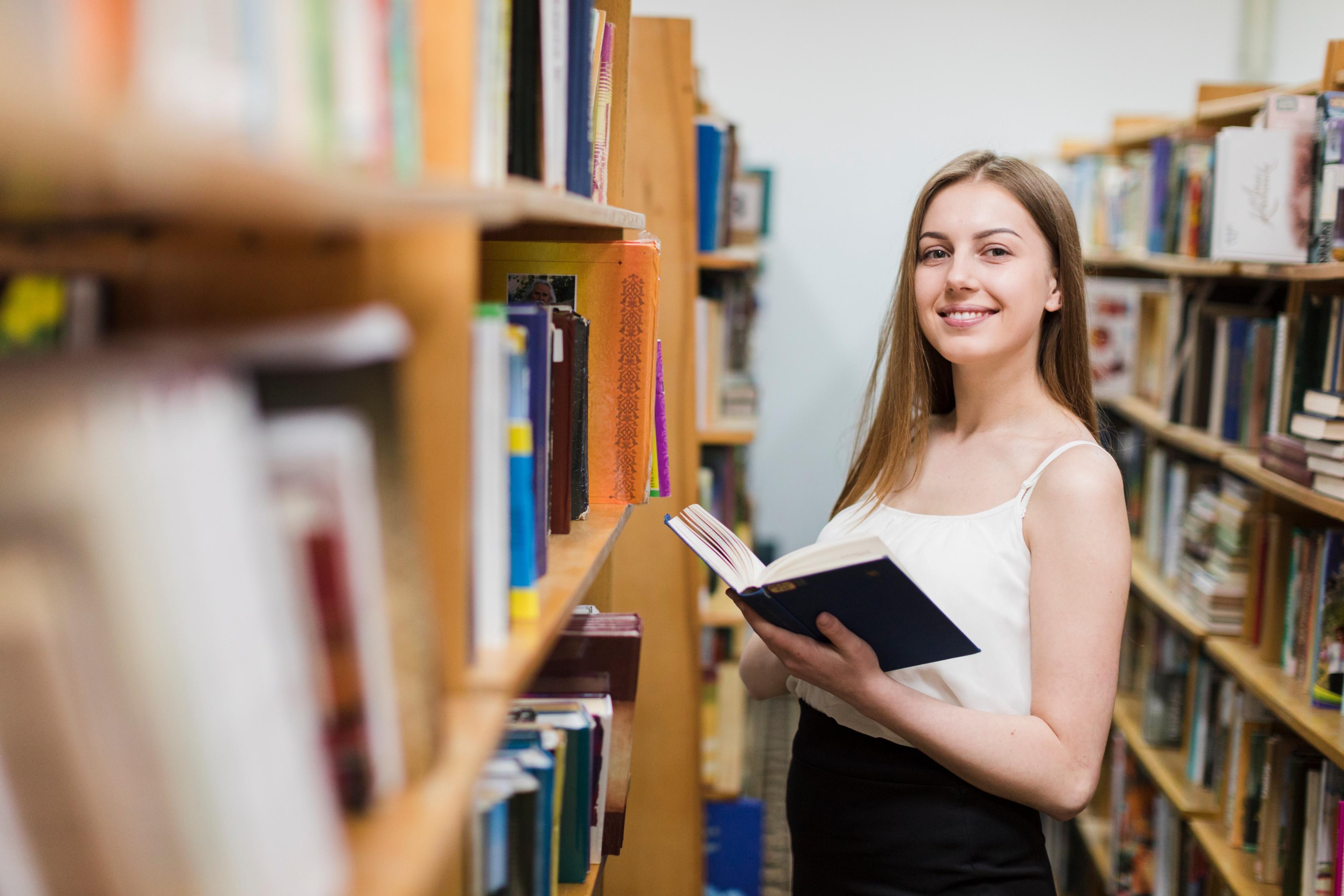 О женщинах в библиотеке. Студентка с книгой. Женщина учится. Девушка с книгой в библиотеке. Фото студентка с книгой в библиотеке.