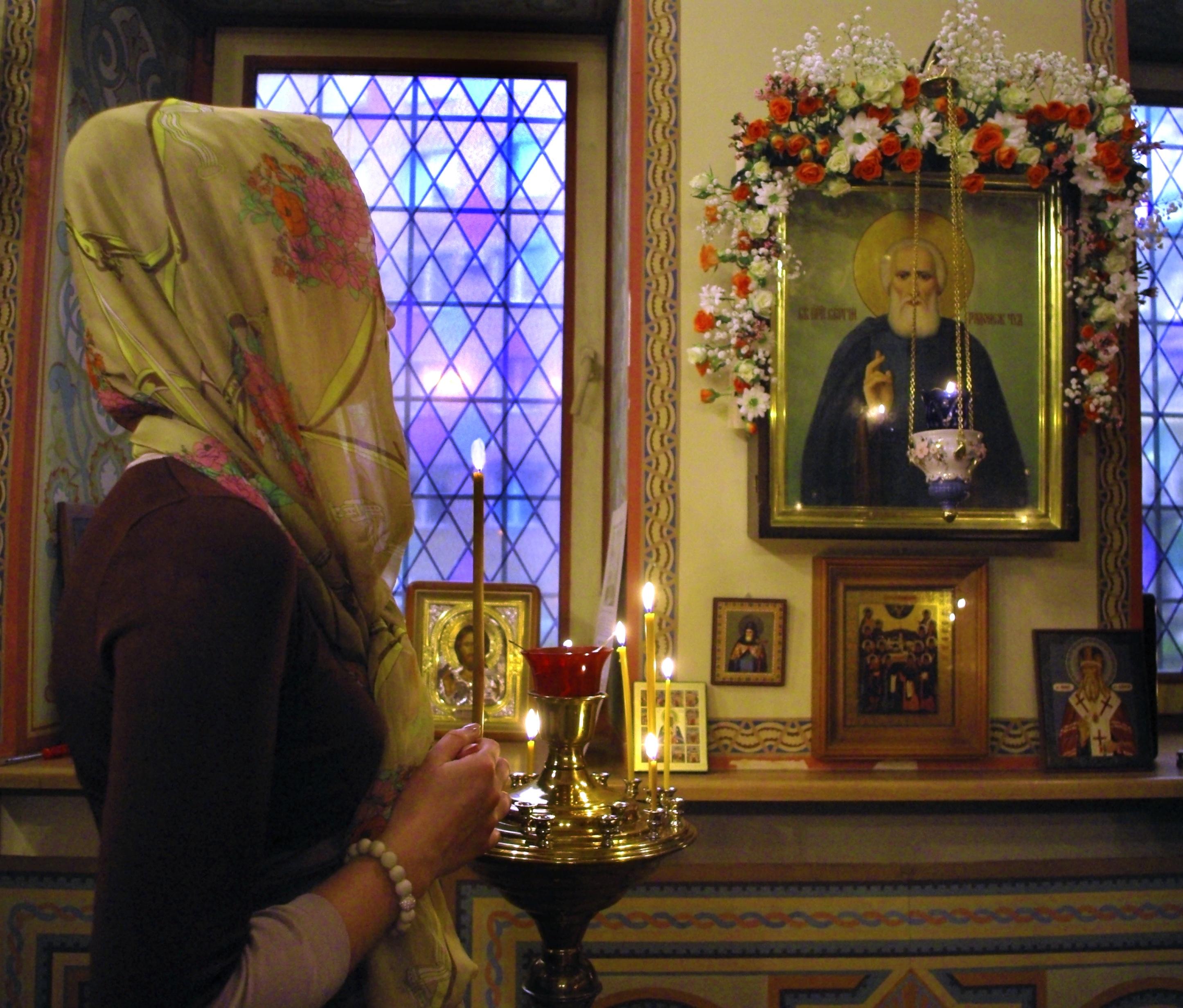 Можно ли молиться перед иконой. Женщина молится в храме. Девушка молится в церкви. Девушка в храме. Женщина у иконы в храме.