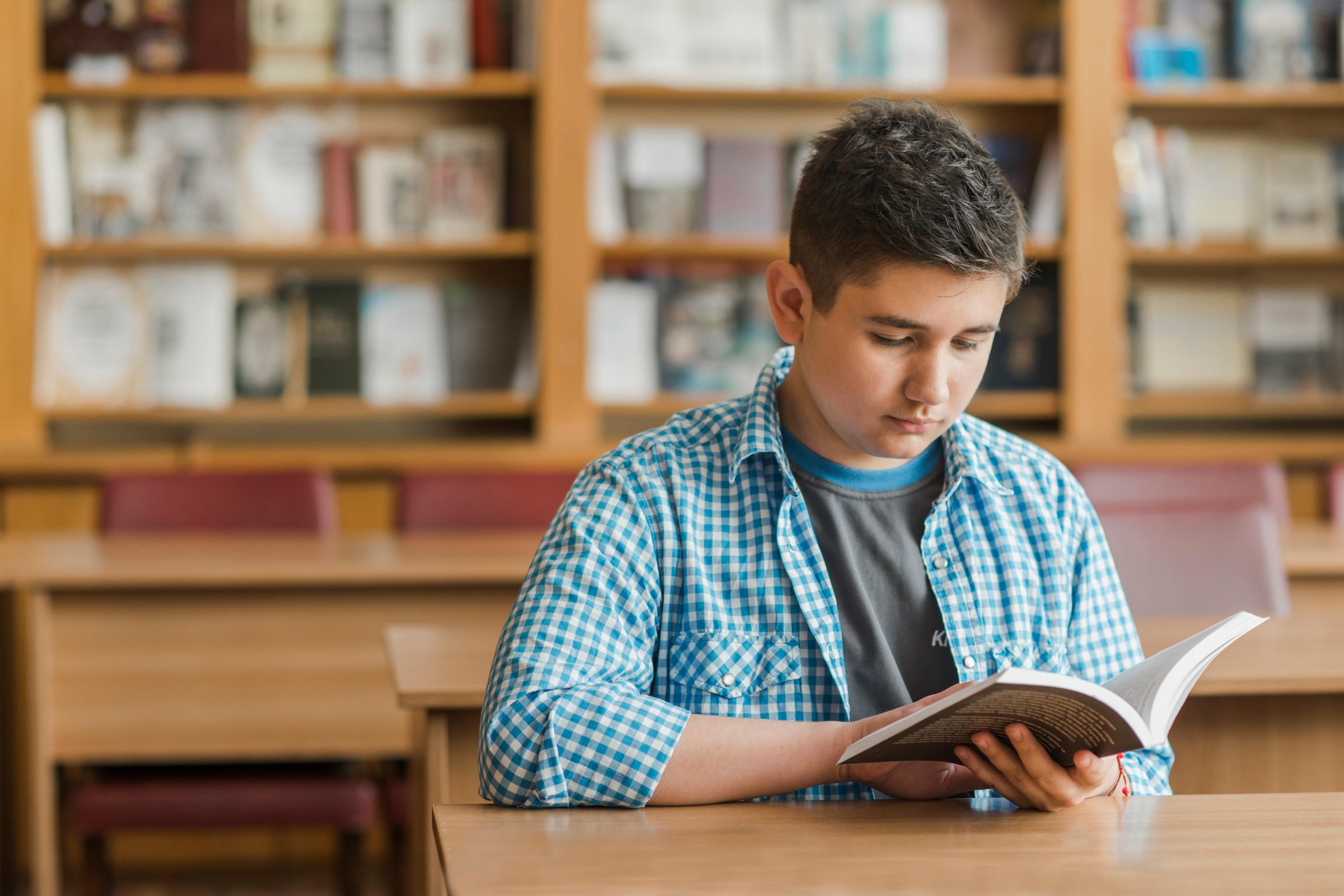 Подросток читает книгу. Подростки в библиотеке. Чтение подростки. Подросток с книгой картинки. Подросток читает книгу картинки.